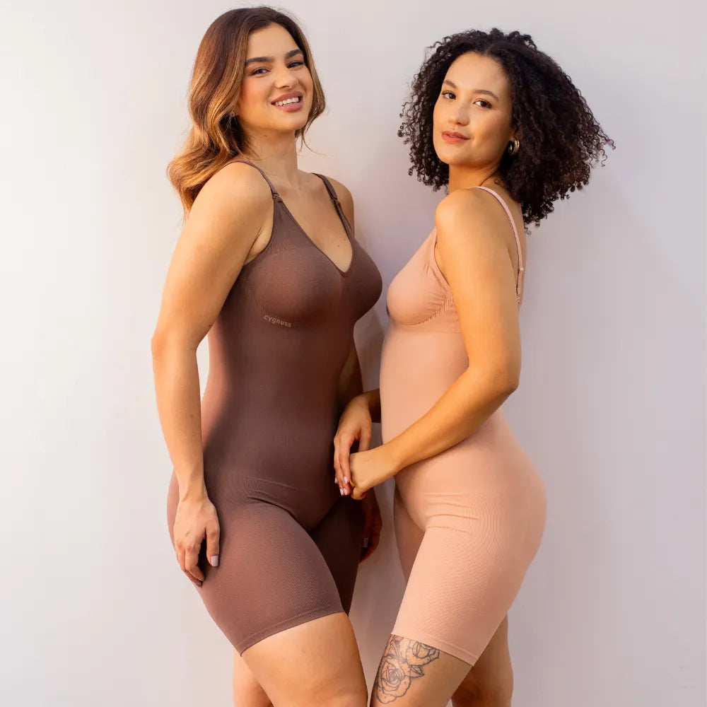Duas mulheres usando o Body Elegance moldeador em tom marrón y tom pele. Ambas estão sorrindo y exibindo o ajuste perfecto y elegante dos bodies, con o logo da Cygnuss visível no canto superior esquerdo de ambas as peças.