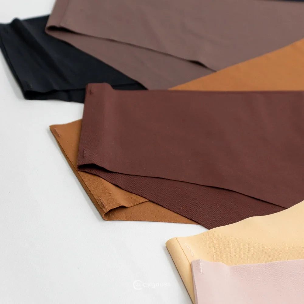 Imagem de calzones sin costuras da Cygnuss em tons neutros, incluindo negro, marrón, caramelo y beige, dispostas sobre uma superfície clara. A variedade de color destaca a versatilidade y sofisticação das peças.