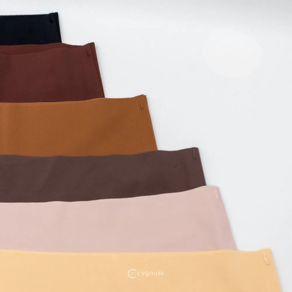 Imagem de calzones sin costuras da Cygnuss organizadas em degradê de tons neutros, incluindo negro, marrón, caramelo, rosado claro y beige. O design minimalista y o acabamento preciso destacam a qualidade das peças