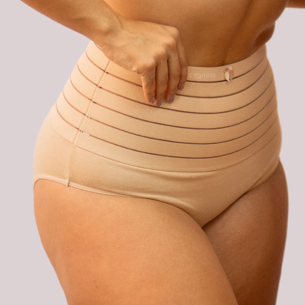 Imagem de mulher usando a calzón moldeador Model - Seca Barriga, em tom beige. A peça de alta compresión tem faixa con listras horizontais, proporcionando controle da barriga y moldeado eficiente da silhueta.
