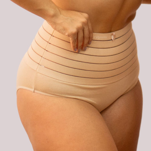 Imagem de mulher usando a calzón moldeador Model - Seca Barriga, em tom beige. A peça de alta compresión tem faixa con listras horizontais, proporcionando controle da barriga y moldeado eficiente da silhueta.