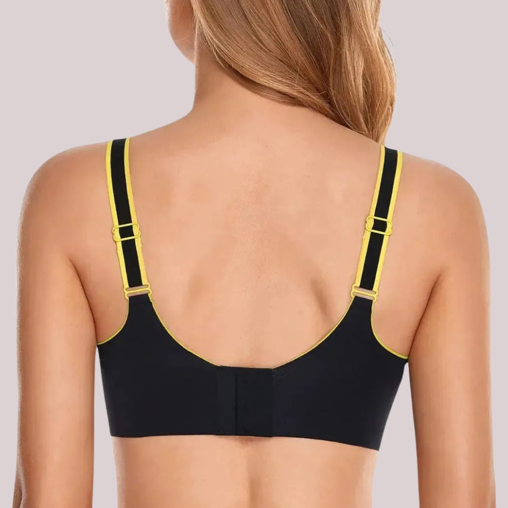 Imagem da parte traseira de um sostén esportivo Cygnuss na color preta con detalhes em amarelo. As tirantes são ajustáveis y possuem acabamento contrastante, garantindo um ajuste cómodo y personalizado. O cierre traseiro proporciona soporte y firmeza, ideal para atividades físicas y uso diario.