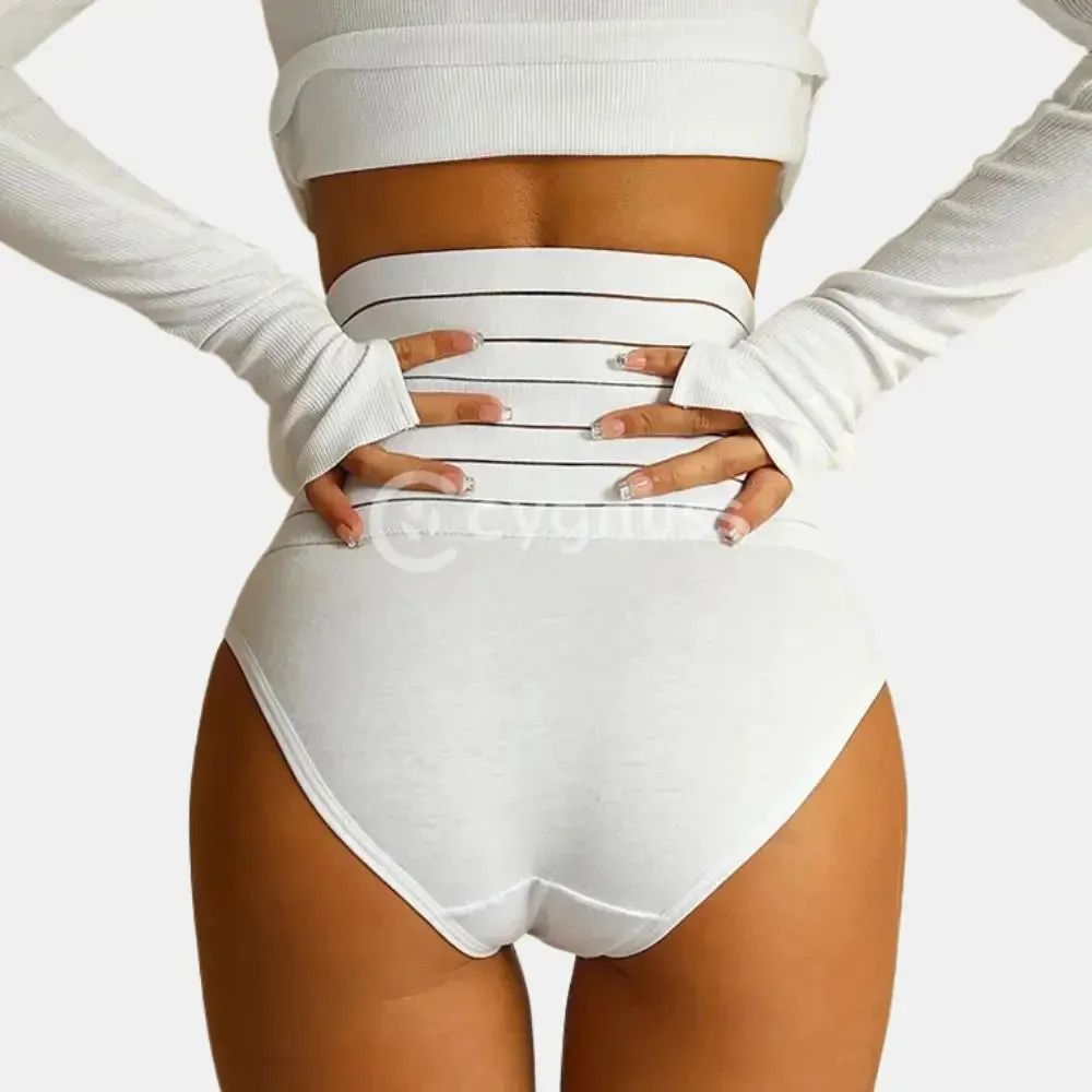 Imagem de uma mulher de espalda, usando uma faja moldeadora branca con faixas de compresión horizontais. A mulher também está vestindo um top de manga longa blanco, con as mãos na cintura, destacando a forma da silhueta modelada pela cinta.