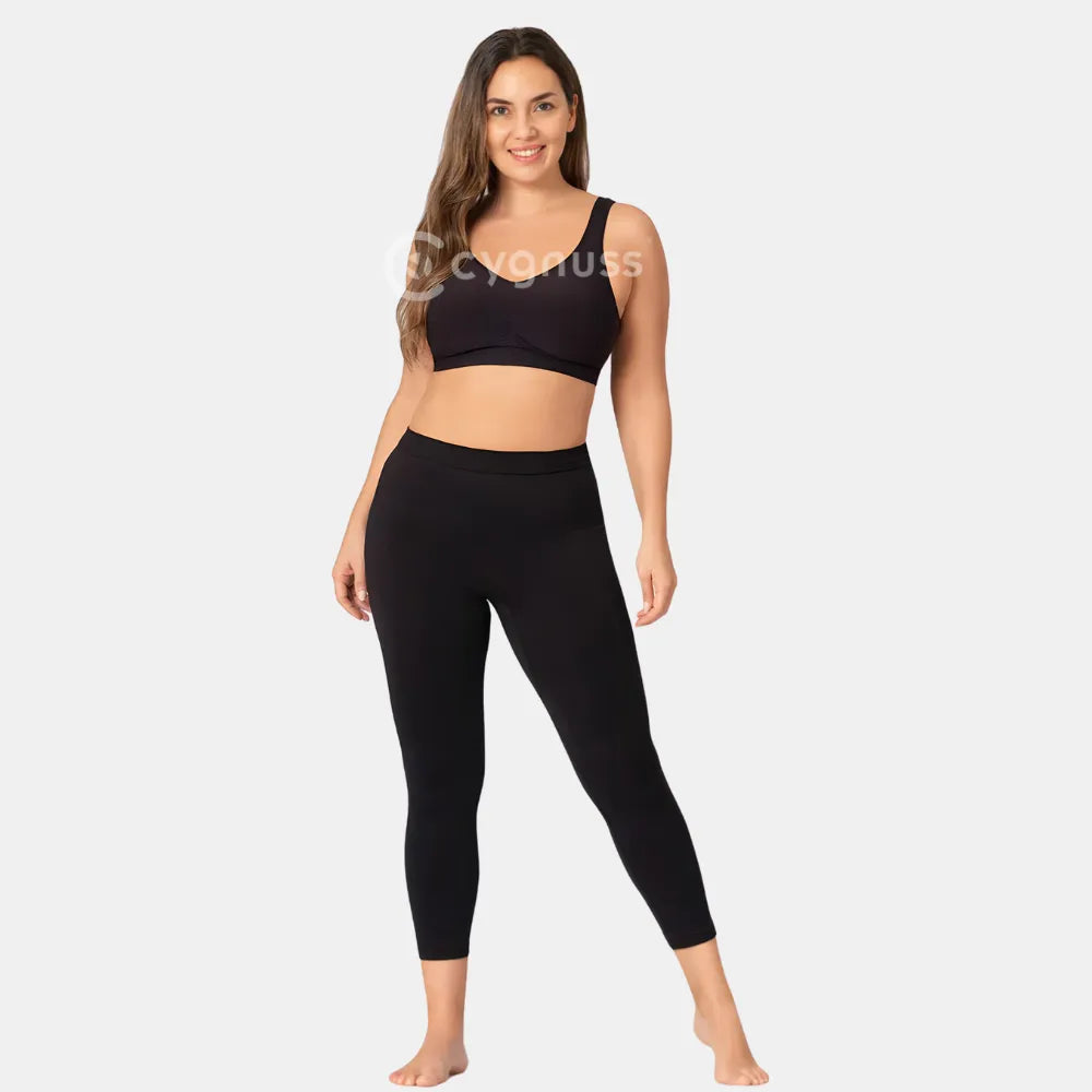 Mulher sorrindo, usando a Legging Jade Fit moldeador de Cós Alto na color preta, combinada con top sin aro, destacando o visual moderno, o cós anatômico y o caimento ajustado até o tornozelo.
