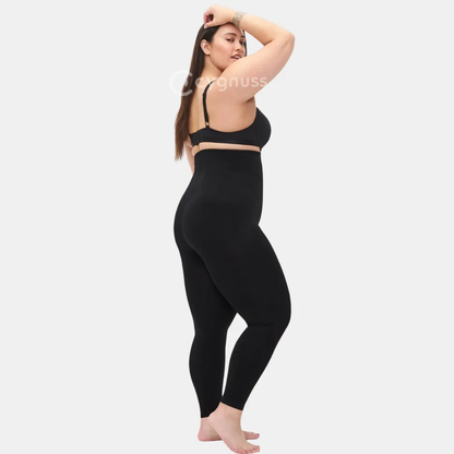 Mulher plus size em pose lateral usando a Legging Jade Fit moldeador de Cós Alto na color preta, destacando o ajuste anatômico, a moldeado que realza as curvas y o cós alto que proporciona firmeza y comodidad.