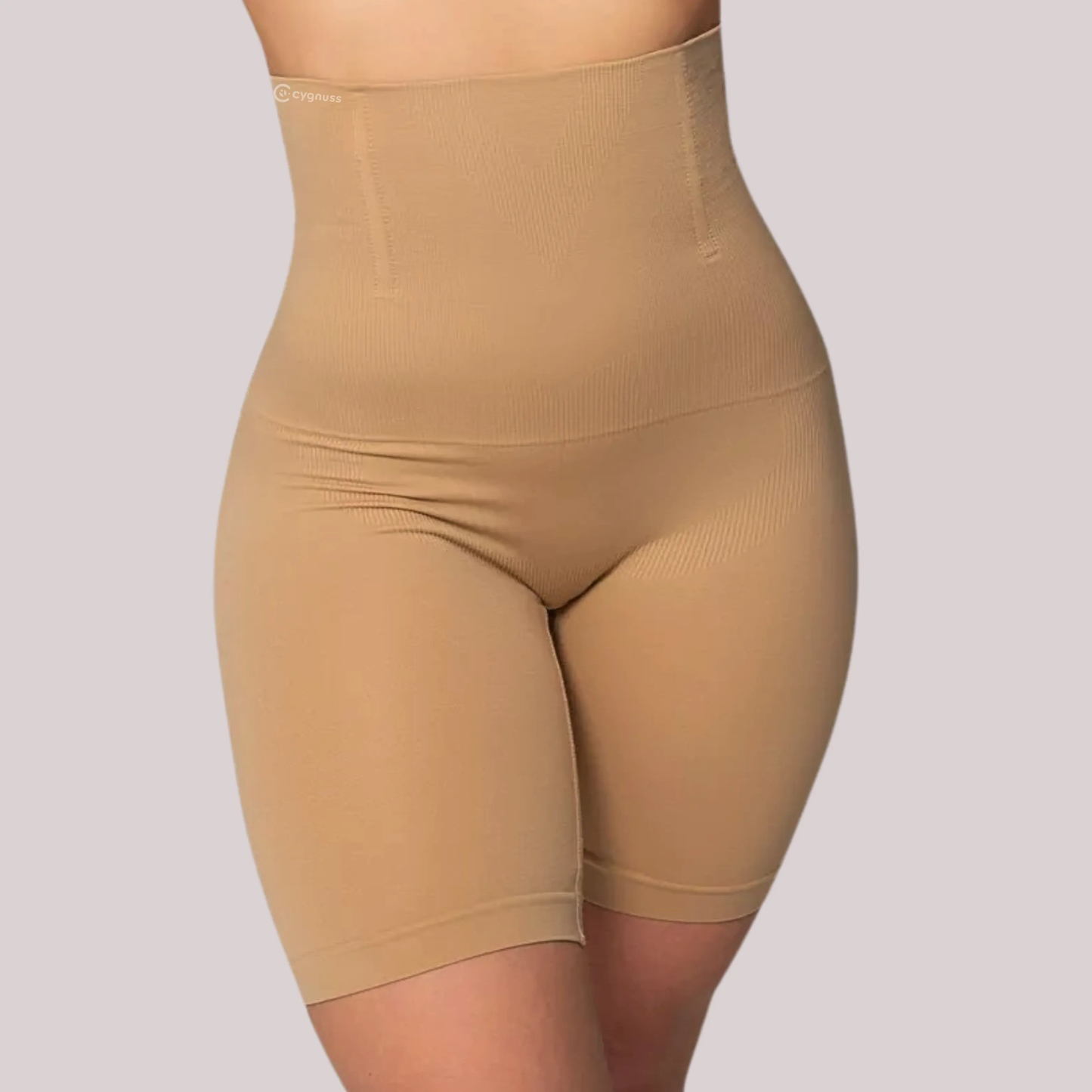 Mulher vestindo o Short Shape moldeador da Cygnuss na color beige, con cintura alta y ballenas de silicone embutidas, oferecendo compresión na barriga, moldeado do quadril y firmeza nas coxas.